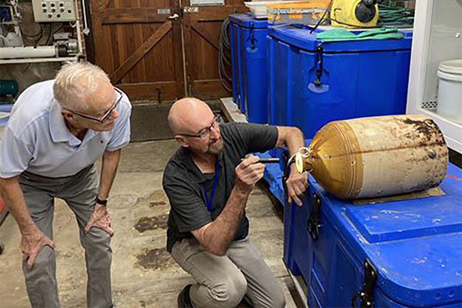 Conservator Jon Carpenter and volunteer Michael Mayers cleaning and inspecting the J & W Bateman. Wine Demijon. Photo WA Museum.
